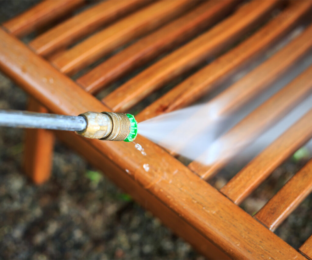 Pressure washing poly furniture slats to remove stubborn buildup.