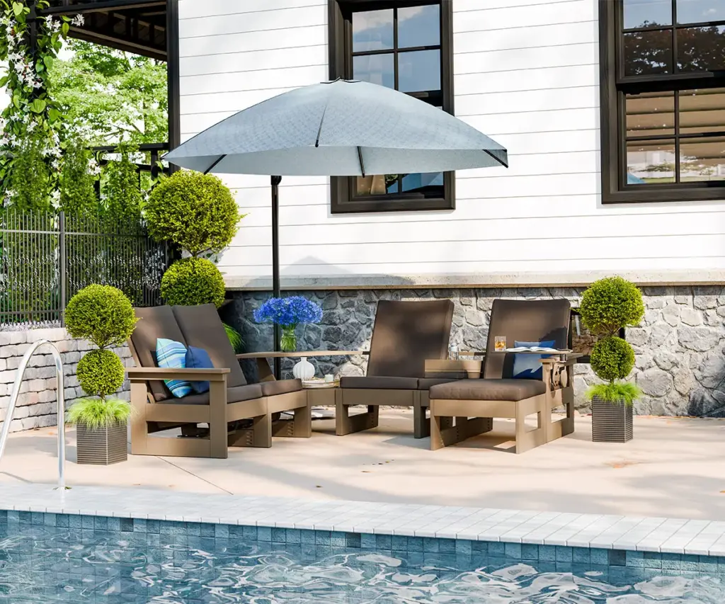 Poly furniture seating arranged beneath an umbrella beside a backyard swimming pool.