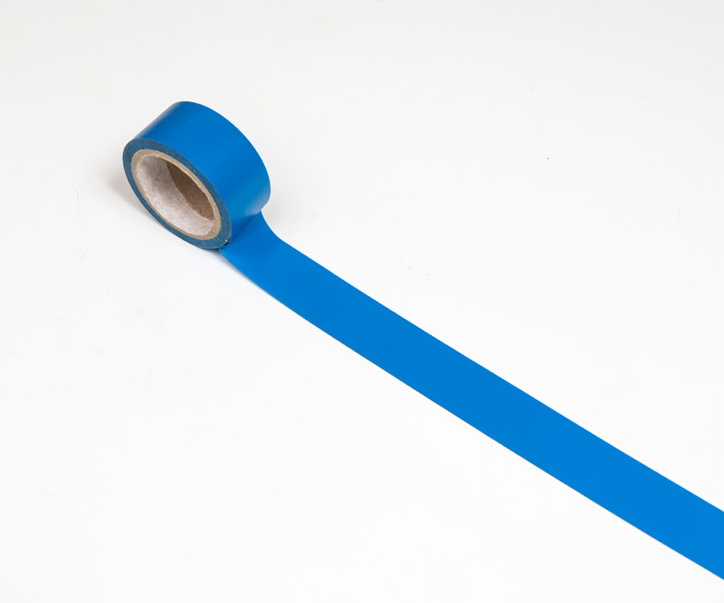 Blue painter’s tape shows how to mark dining table size on the floor.